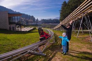 Sweden, 2022 - Happy family enjoying alpine coaster photo