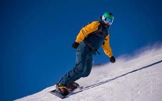 snowboarder running down the slope and ride free style photo