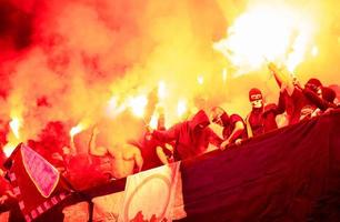 Croatia, 2022 - football hooligans with mask holding torches in fire photo