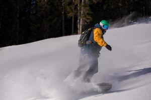 snowboarder running down the slope and ride free style photo