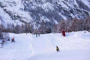 rescue team with a red helicopter rescuing a hurt skier photo