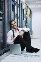 businessman with laptop in network server room photo