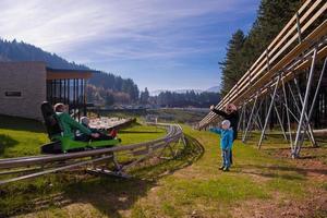 Sweden, 2022 - Happy family enjoying alpine coaster photo