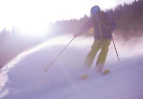 Skier having fun while running downhill photo