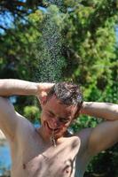 young man relaxing under shower photo