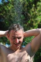 young man relaxing under shower photo