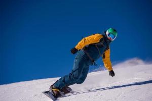 snowboarder running down the slope and ride free style photo