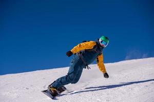 snowboarder running down the slope and ride free style photo