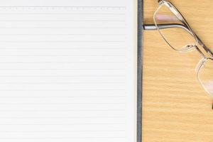 Notebook open blank page and eyeglasses photo