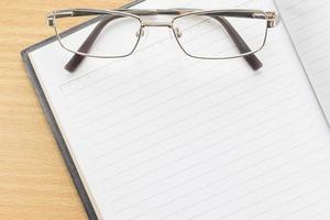 Notebook open blank page and Eyeglasses photo