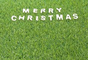 Christmas wood alphabet on green grass photo