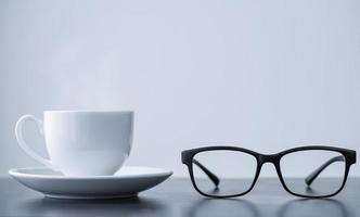 Coffee cup and glasses on desk photo