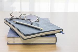 Black book with glasses and pen photo