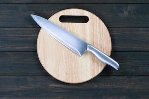 Close up kitchen knife and wooden round cutting board photo