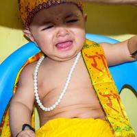 lindo niño indio disfrazado de pequeño señor krishna con motivo del festival radha krishna janmastami en delhi india foto