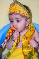 lindo niño indio disfrazado de pequeño señor krishna con motivo del festival radha krishna janmastami en delhi india foto