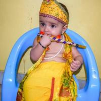 lindo niño indio disfrazado de pequeño señor krishna con motivo del festival radha krishna janmastami en delhi india foto