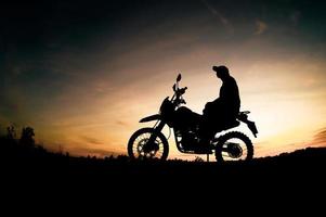 Men's silhouettes and touring motocross bikes. Park to relax in the mountains in the evening. adventure travel and leisure concept photo