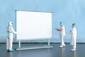 Miniature Doctor standing With Blank White Board photo