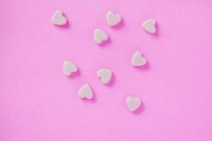 valentine candy hearts shape on pink background photo