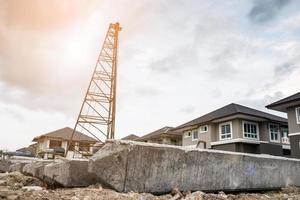 house building at construction site with pile driver and concrete piles photo