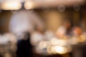 Chef cooking in restaurant kitchen abstract blurred defocused background photo