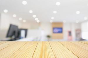 Wood table with Abstract blur office desk workplace with computer defocused background photo