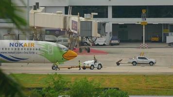 phuket, tailandia 1 de diciembre de 2016 - nok air boeing 737 hs dbv remolque antes de la salida. vista desde el último piso del hotel centara grand west sands resort phuket video