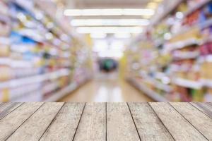 Wood table top with Supermarket aisle blur abstract background photo