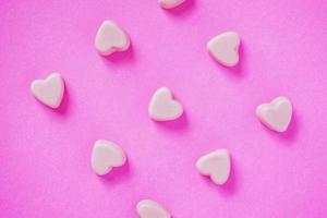 valentine candy hearts shape on pink background photo