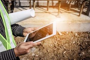 construction engineer worker using tablet computer at building site photo