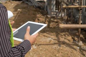 construction engineer worker using tablet computer at building site photo
