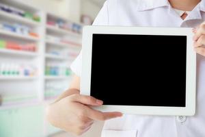 farmacéutico que muestra la promoción que muestra la pantalla en blanco de la tableta foto