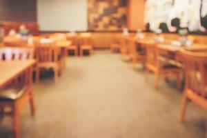 el interior del restaurante con el cliente y la mesa de madera desdibujan el fondo abstracto con la luz del bokeh foto