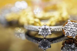 anillos de diamantes de joyería de oro de lujo con reflejo en el fondo negro foto