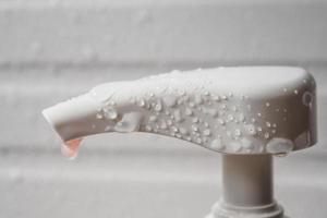 gota de agua en la bomba dispensadora de jabón líquido durante el baño foto