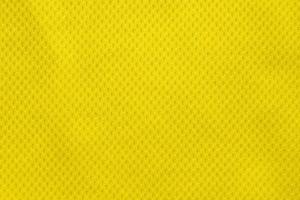 Yellow color football jersey clothing fabric texture sports wear background, close up photo