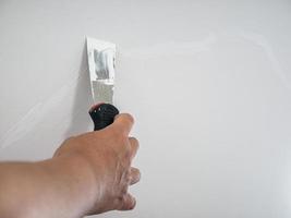 yesero mano reparación grieta pared blanca foto