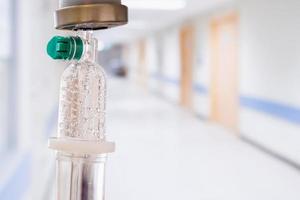 Medical drip with hospital blurred background photo