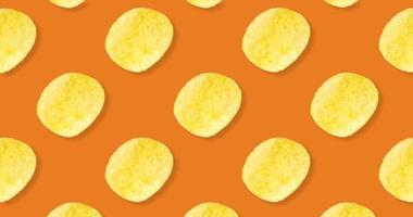 Potato chips pattern on pastel orange background top view flat lay photo