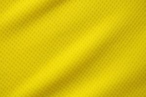 Yellow color football jersey clothing fabric texture sports wear background, close up photo