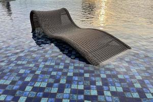 relax deck chair by the blue pool at swimming pool in luxury spa resort or villa Tourism industry photo