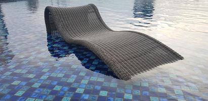 relax deck chair by the blue pool at swimming pool in luxury spa resort or villa Tourism industry photo