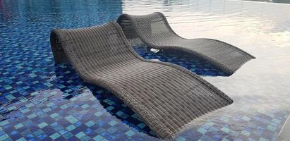 relax deck chair by the blue pool at swimming pool in luxury spa resort or villa Tourism industry photo