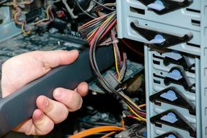 Cleaning the system unit of a desktop computer from dust using a vacuum cleaner photo