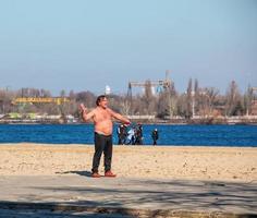 dnepr, ucrania - 02.21.2022 un hombre de mediana edad hace gimnasia en la orilla del río. el concepto de un estilo de vida saludable y la lucha contra el peso de la línea. foto