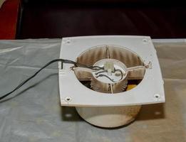 Close-up of a very dirty kitchen exhaust fan. Fan before preventive cleaning and washing. Dirty details photo