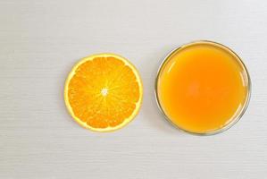 A glass of orange juice and sliced oranges top view isolated on white background photo