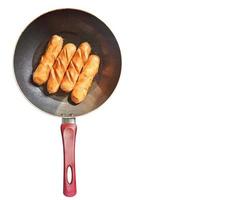 Sausages fried in a separate pan on white background and space for text . Top view. photo