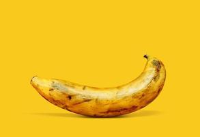 fruta de plátano muy madura sobre un fondo amarillo foto